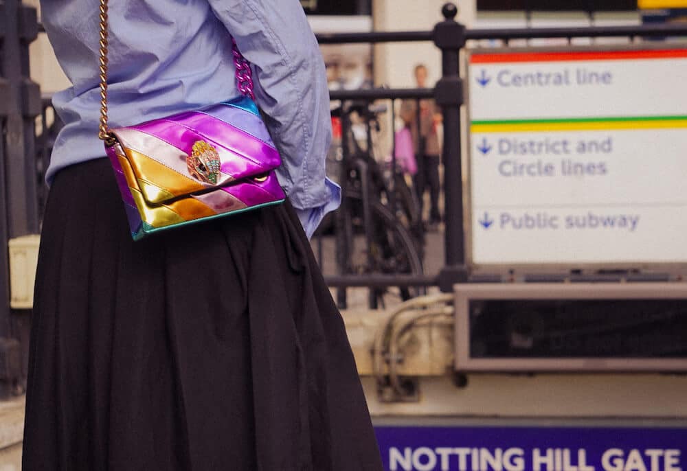 Woman in street with a Kurt Geiger handbag