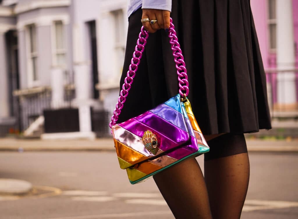 Woman in street holding a Kurt Geiger bag